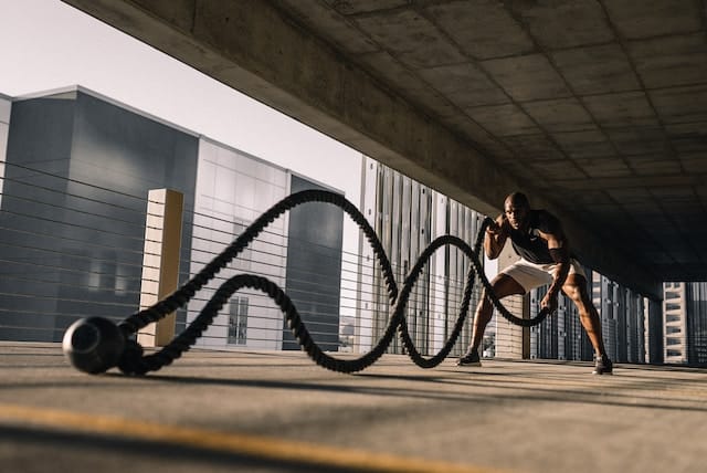 Man intensely working out with battle ropes, showcasing dynamic Heart Pumping Action' in motion
