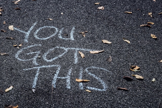 Chalk-written encouragement 'You got this 'on the floor, symbolizing the drive to Stay Motivated and Overcome Plateaus in fitness journeys.